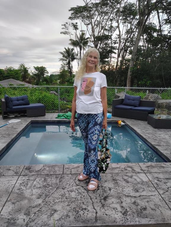 a woman standing in front of a swimming pool at Hoomaikai Blessings in Keaau