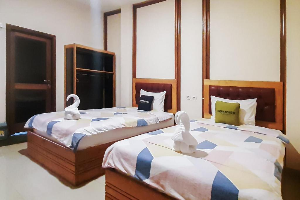 Postel nebo postele na pokoji v ubytování Urbanview Remington Hotel Palembang By RedDoorz