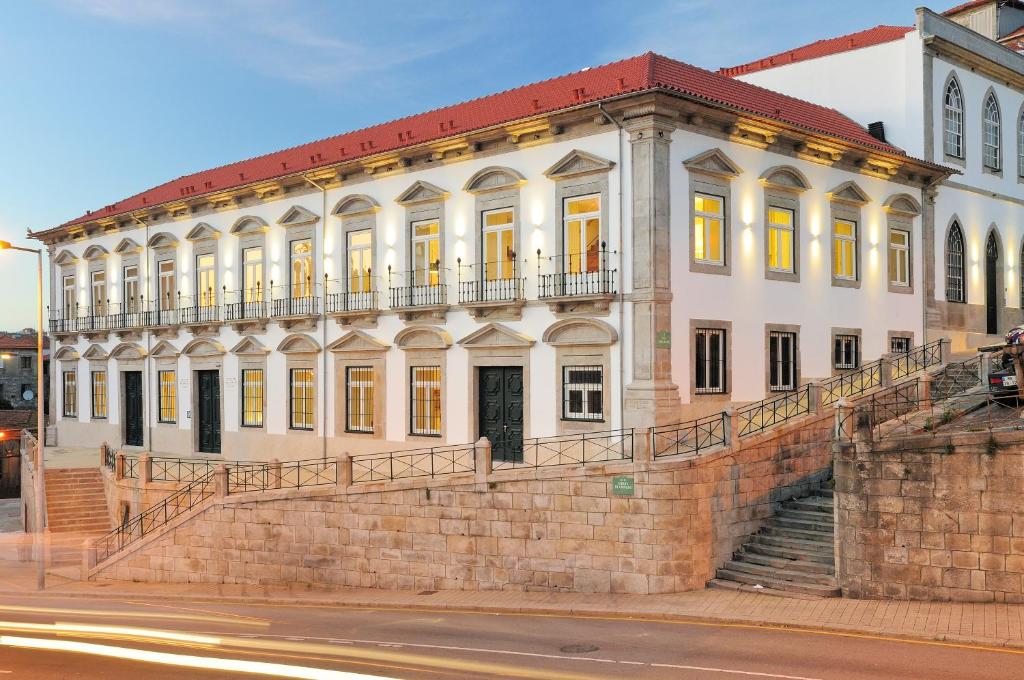un grande edificio bianco sul lato di una strada di Condes de Azevedo Palace Apartments a Porto