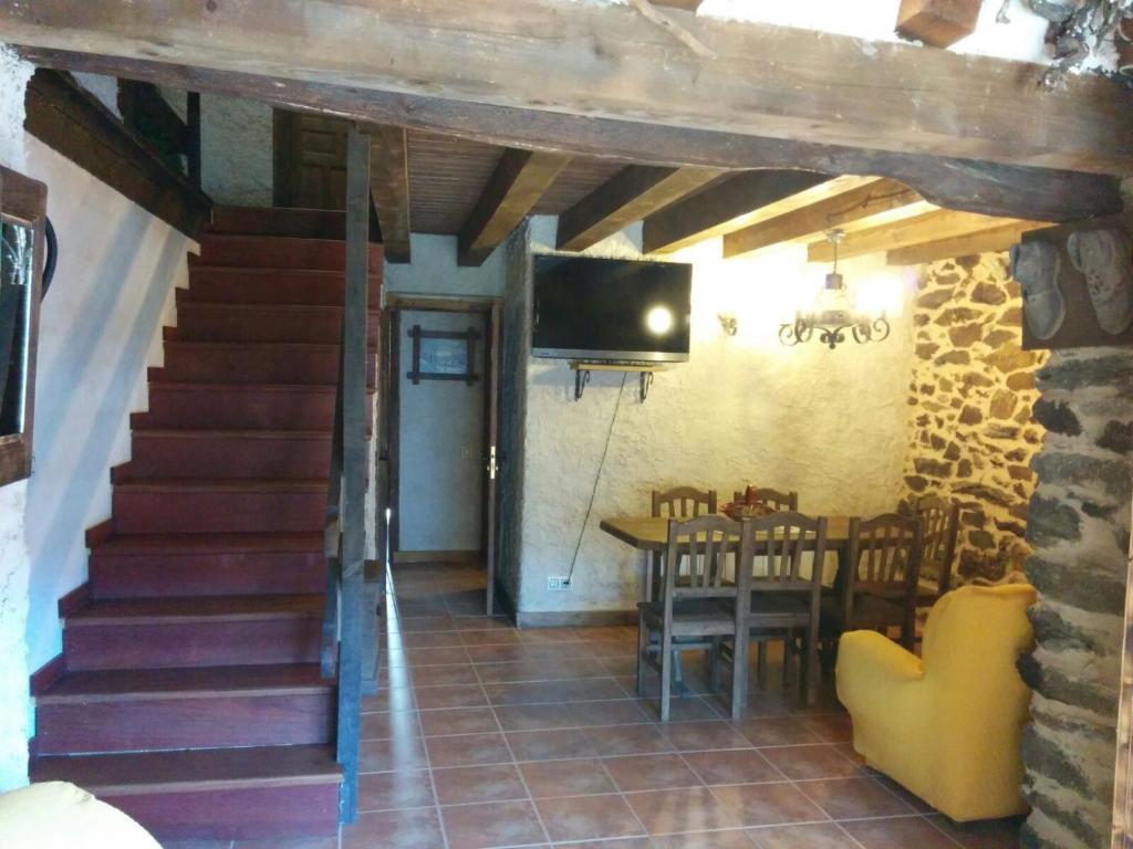 a room with stairs and a table and a television at Casa Rural Xiromo in San Ciprián