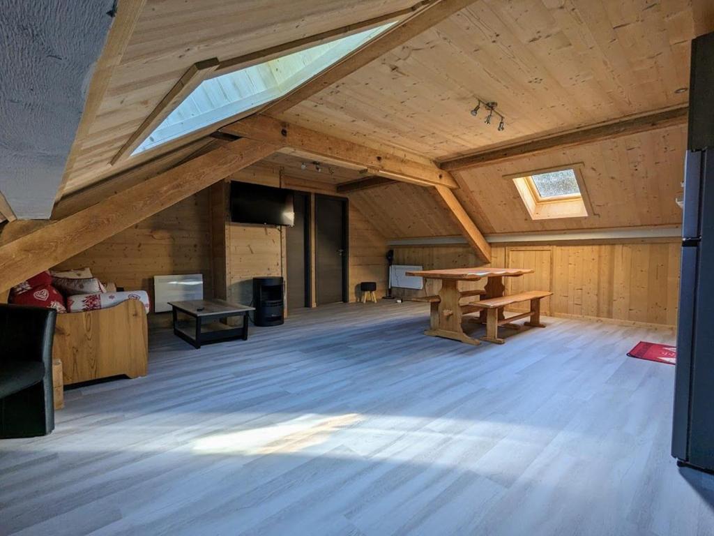 Cette grande chambre dispose de parquet et d'une table en bois. dans l'établissement Appartement 42m² cosy avec parking, WiFi, proche pistes, La Bresse - FR-1-589-684, à La Bresse