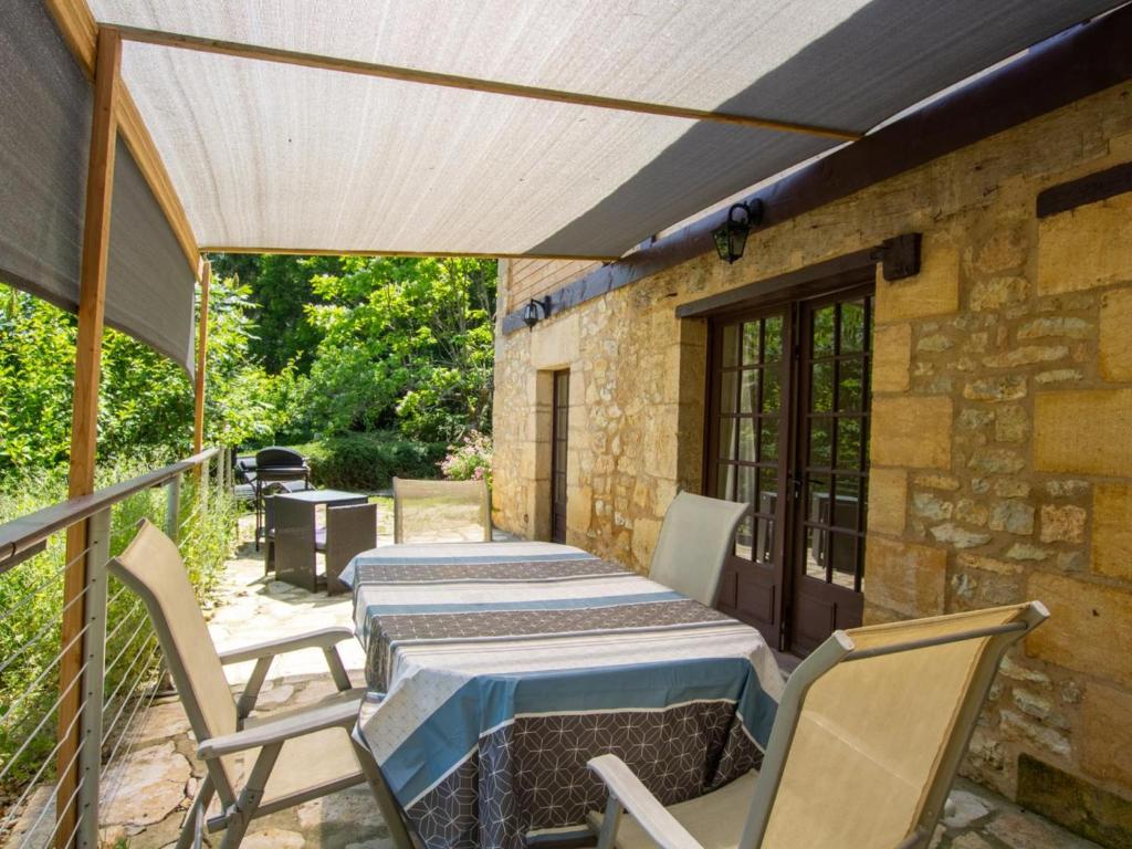 a patio with a table and chairs on a porch at Maison de charme avec jardin clos et Wifi au cœur du Périgord Noir - FR-1-616-401 in Saint-Pompont