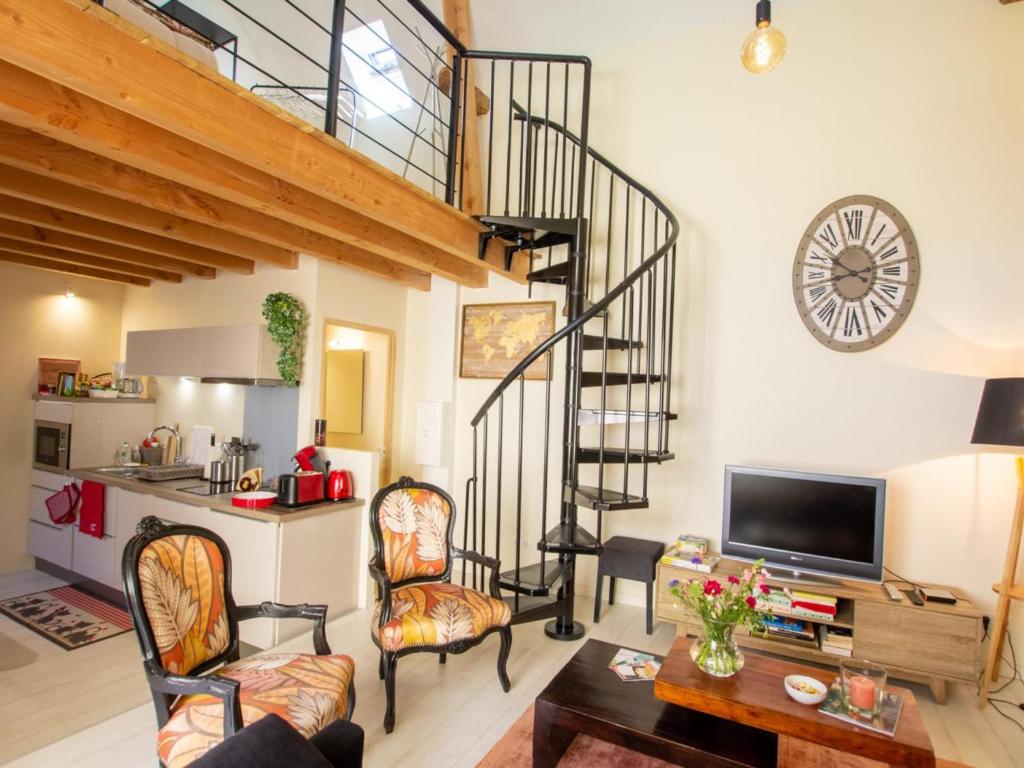a living room with a spiral staircase and a clock at Chaleureuse escapade périgourdine avec terrasse et mezzanine - FR-1-616-419 in Auriac-du-Périgord