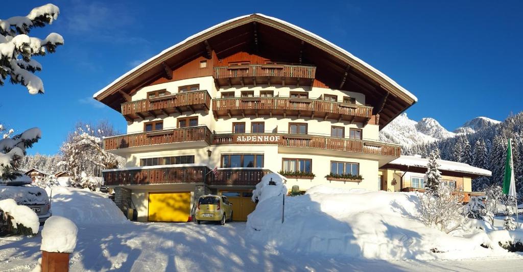 a large building in the snow with a lot of snow at Alpenhof in Ramsau am Dachstein