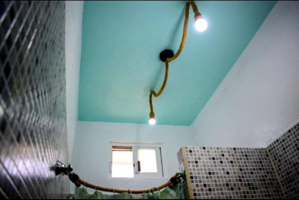 ein Bad mit blauer Decke und Fenster in der Unterkunft Little Oasis Cozumel in Cozumel