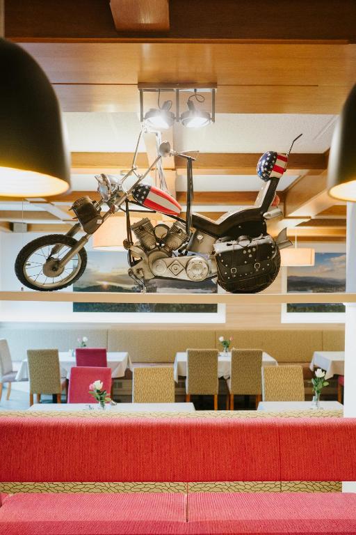 a motorcycle hanging on a wall in a restaurant at Der Thomashof in Sankt Jakob im Rosental