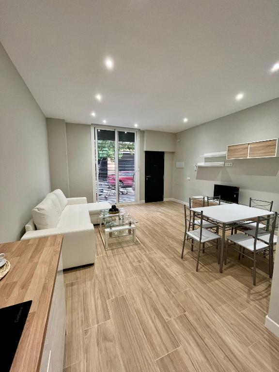 un salon avec un canapé blanc et une table dans l'établissement Jardines Suites GP, à Cordoue