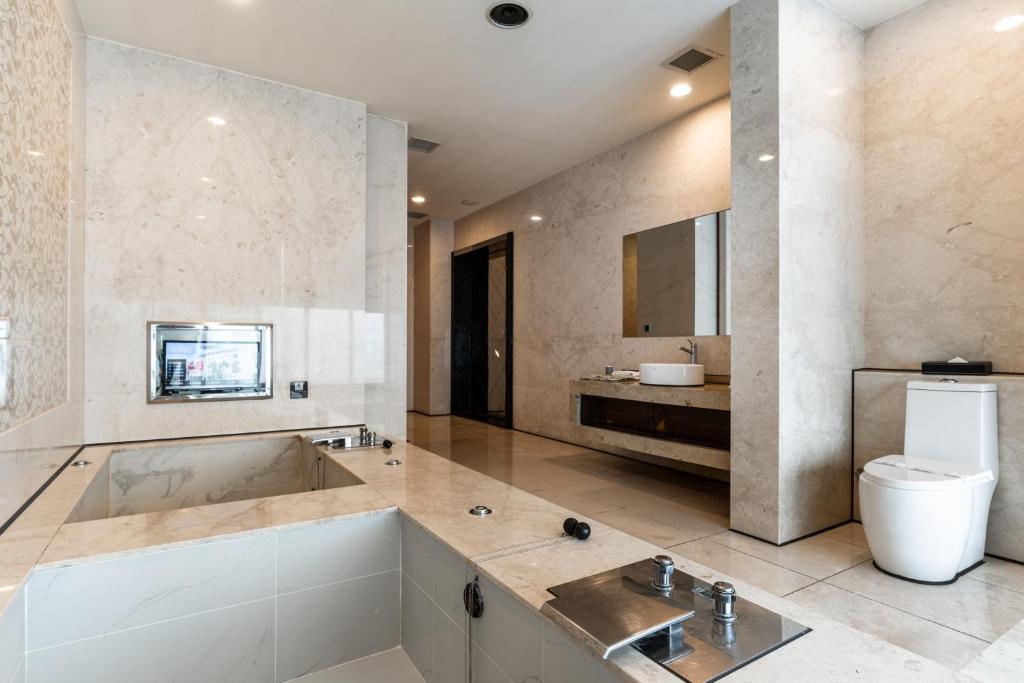 a bathroom with a tub and a toilet and a sink at OHYA Chain Boutique Motel Taoyuan in Taoyuan