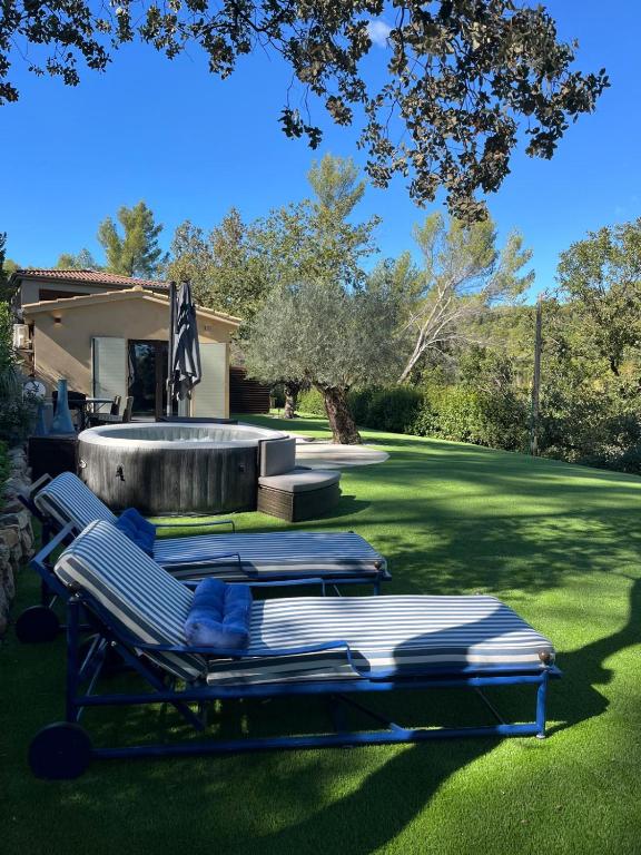 un groupe de chaises longues sur une pelouse dans l'établissement Maisonnette climatisée, à Aix-en-Provence