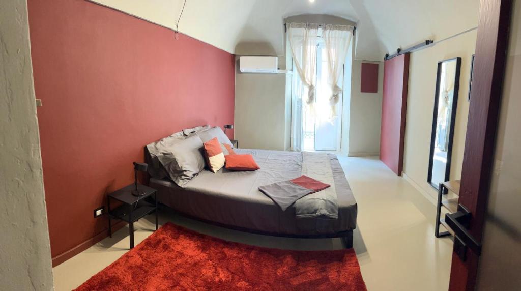 a bedroom with a bed with a red wall at Castellazzo 1 in Ivrea