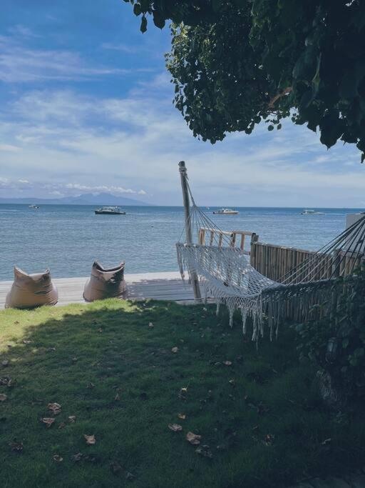 un banc blanc assis sur l'herbe près de l'eau dans l'établissement Purnama Home, à Toyapakeh