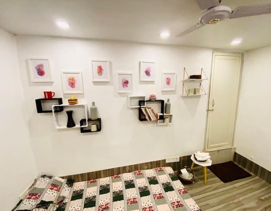 a bedroom with a bed and shelves on the wall at Budget friendly Mini Heaven 2 in Kolkata
