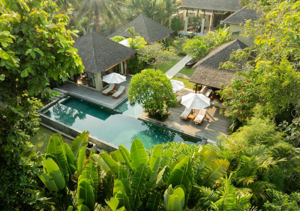 einen Luftblick auf einen Pool mit Sonnenschirmen des Resorts in der Unterkunft Villa Nelayan by Nakula in Canggu