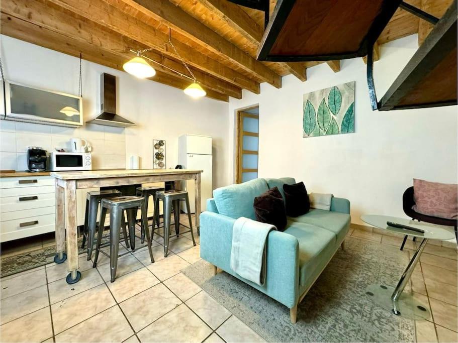 un salon avec un canapé et une cuisine dans l'établissement Maison Entre Pont et Cathédrale, à Béziers