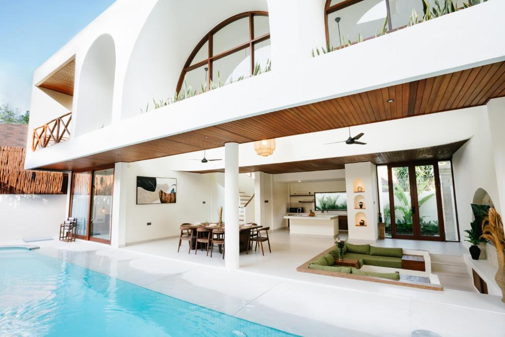 an open living room and dining area of a house with a swimming pool at Luxury Villa Noah - Walkable to Shopping Mall & Waterbom Bali in Kuta