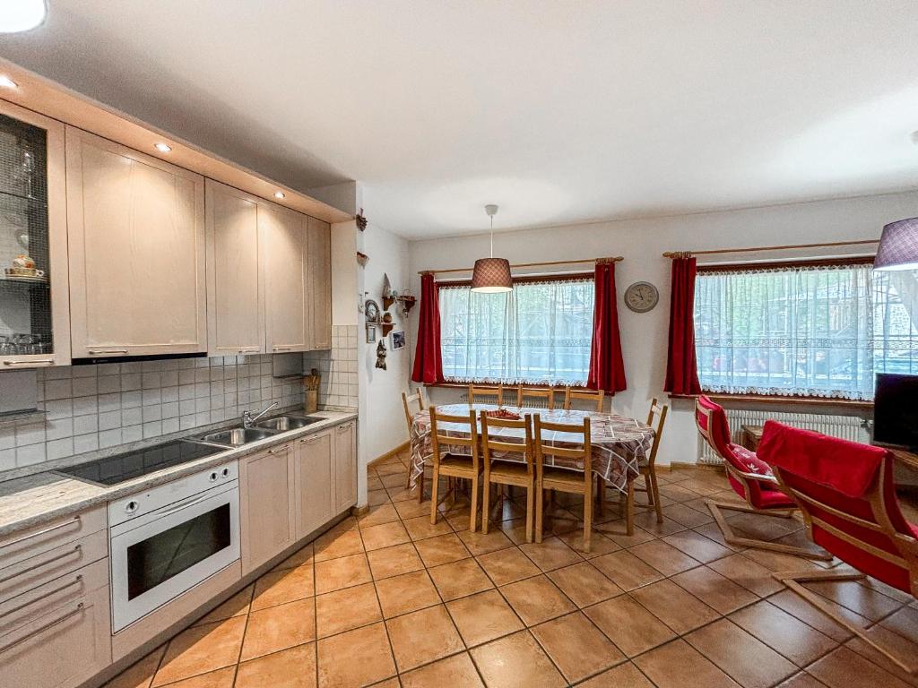 a kitchen with a table and a dining room at Appartamento Al Ruscello in Canazei