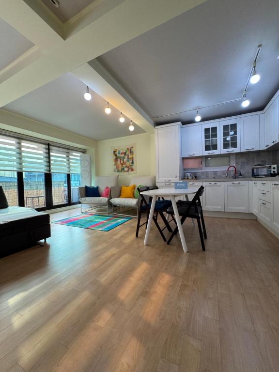 eine Küche und ein Wohnzimmer mit einem Tisch und einer Couch in der Unterkunft Hongdae, Private Flats in Seoul