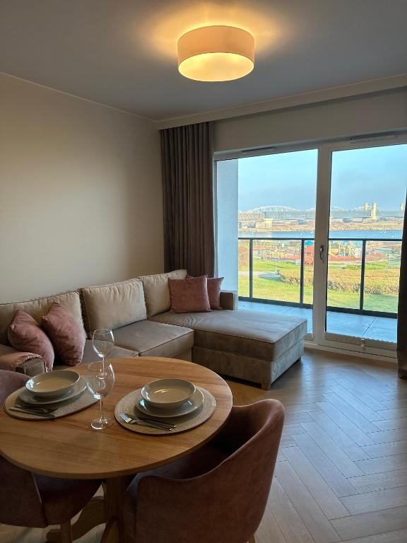 a living room with a table and a couch at Apartament Premium Zamkowa A14 in Tczew