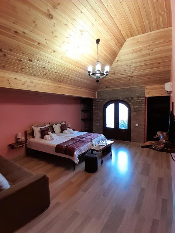 a large bedroom with a bed and a wooden ceiling at Château Fort de Manavi, Boutique Hotel in Manavi
