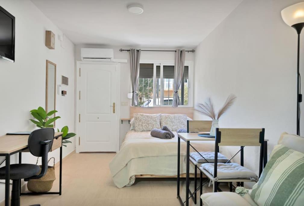 une chambre avec un lit, une table et des chaises dans l'établissement Estudio con wifi piscina y parking en Benalmádena - ACUARIO 5, à Benalmádena