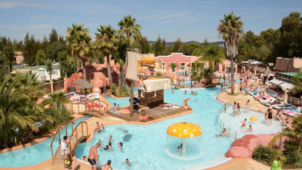 une vue aérienne d'une piscine dans un complexe hôtelier dans l'établissement Camping Les Palmiers, à Hyères