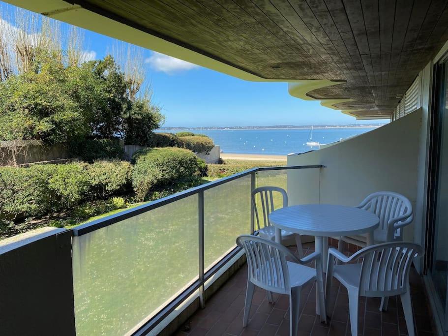 un balcon avec une table et des chaises et l'océan dans l'établissement Appartement accès direct plage, à Arcachon