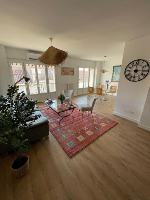 un salon avec un canapé et une horloge au mur dans l'établissement Beautiful - Balcony - Close train and port, à Toulon