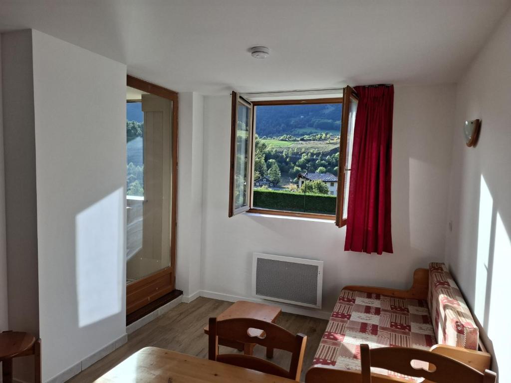 un salon avec une table et une fenêtre dans l'établissement Terrasses F 004 PARC NAT VANOISE appart 6 pers, à Val Cenis