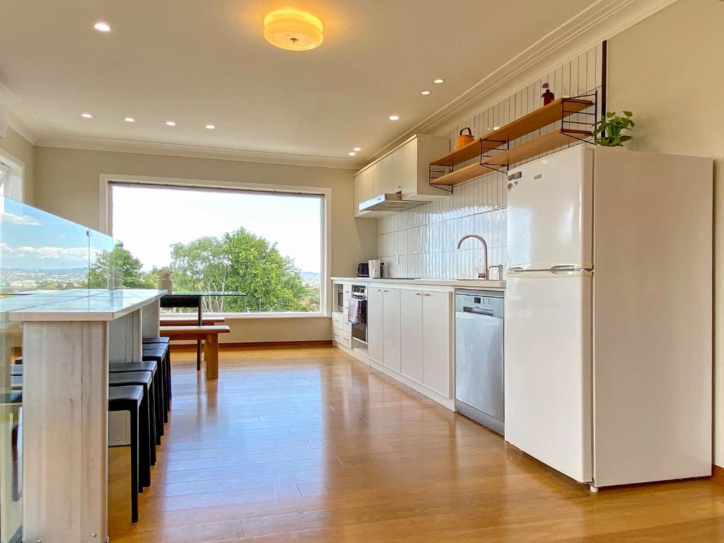a kitchen with a white refrigerator and a table at Cosy family house in Massey with Good View in Auckland