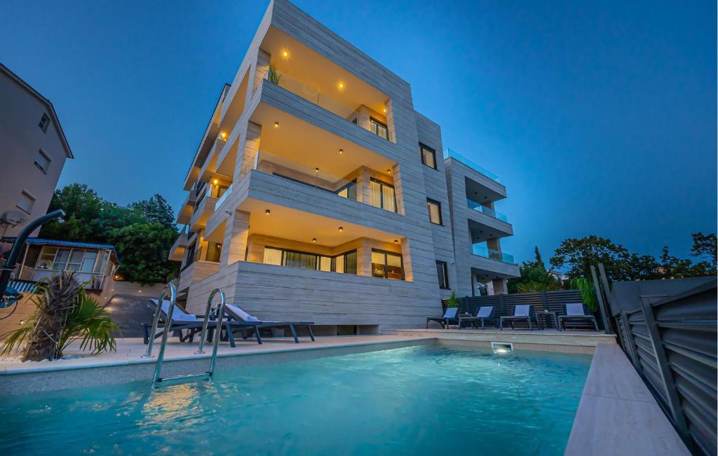 a building with a swimming pool in front of a building at Lovely Apartment In Crikvenica in Crikvenica