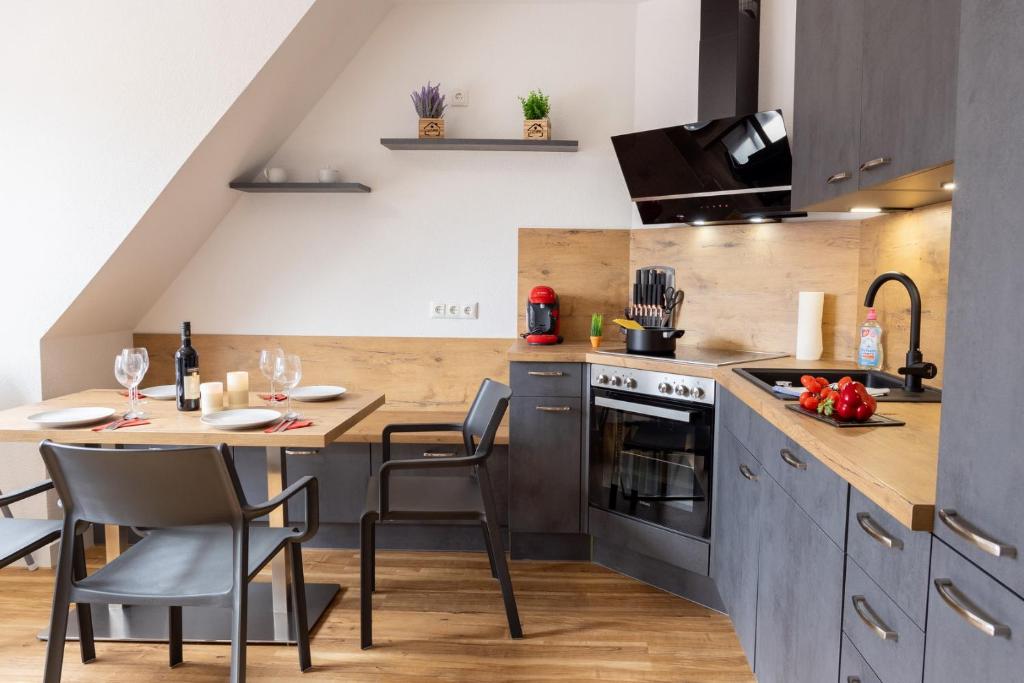 a kitchen with a table and chairs and a counter at Ferienhaus Brockenoase Apartment Bergzauber in Benneckenstein