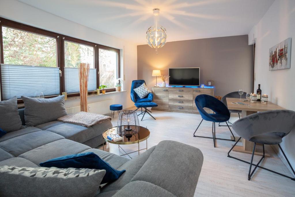 ein Wohnzimmer mit Sofa, Sesseln und Fernseher in der Unterkunft Bismarckstraße 27 in Bad Sachsa
