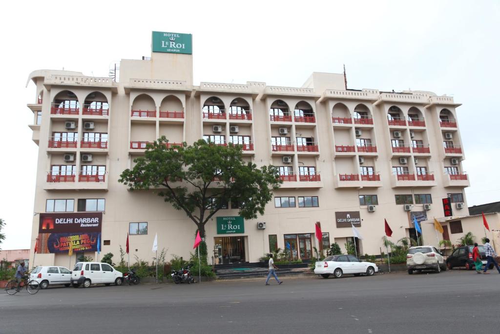 a large building with cars parked in front of it at Le Roi Udaipur in Udaipur