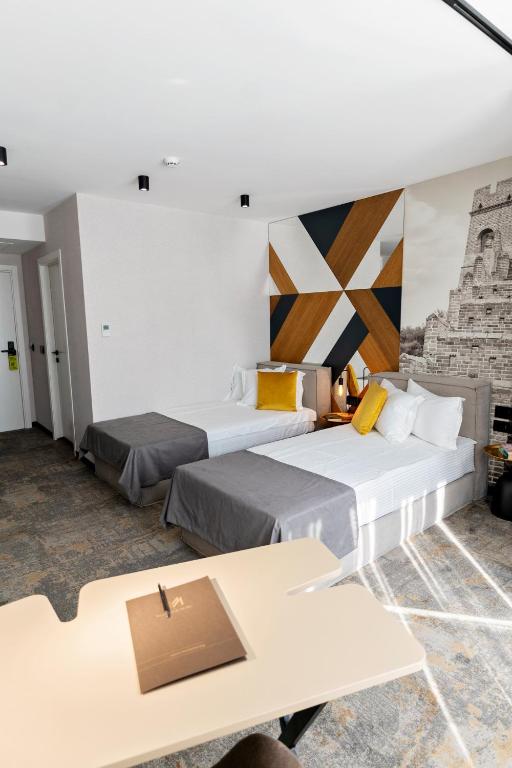 a hotel room with two beds and a table at MM Boutique Hotel in Burgas