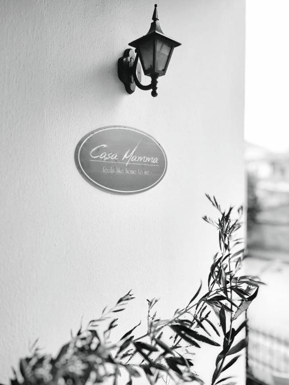 a sign on a wall with a lamp and a plant at CasaMamma in Drama