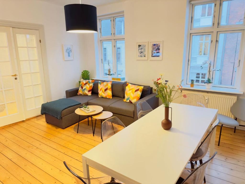 オールボーにあるaday - Central Charming 2 bedrooms Apartmentのソファとテーブルのあるリビングルーム
