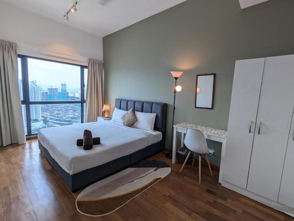 a bedroom with a bed and a desk and a window at Reizz Residence Majesty Suite in Kuala Lumpur