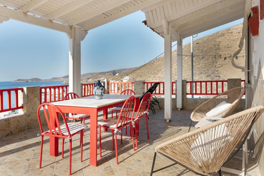 a table and chairs on a patio with a view of the ocean at Villa Christina 2 Kythnos in Mérikhas