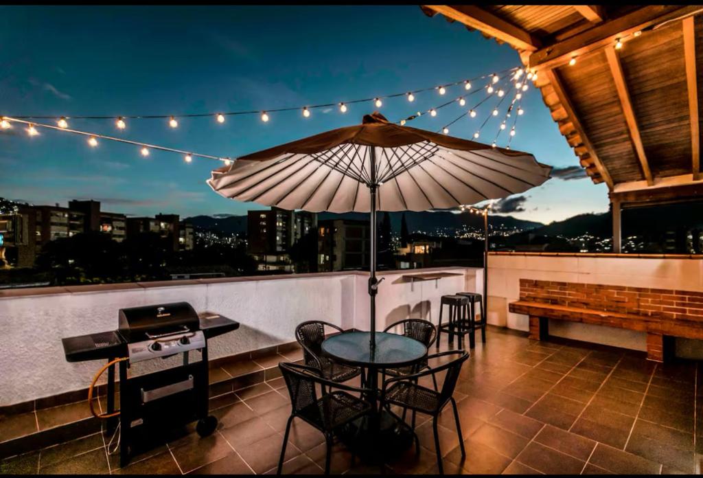 a patio with a table and chairs and an umbrella at Disfruta de la comodidad como un Hotel 5 Estrellas in Envigado
