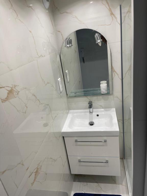 une salle de bain blanche avec un lavabo et un miroir dans l'établissement Studio Lumineux à 2min de là plage, à Nice