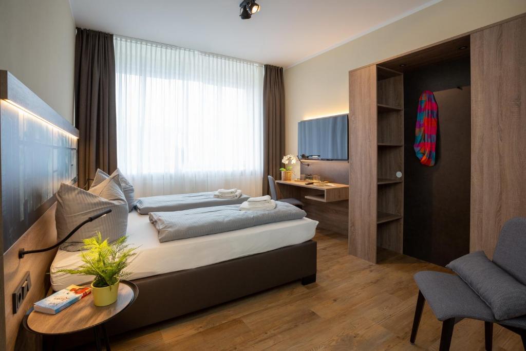 a bedroom with two beds and a table and a chair at Lieblingsquartier komplett in Sankt Andreasberg
