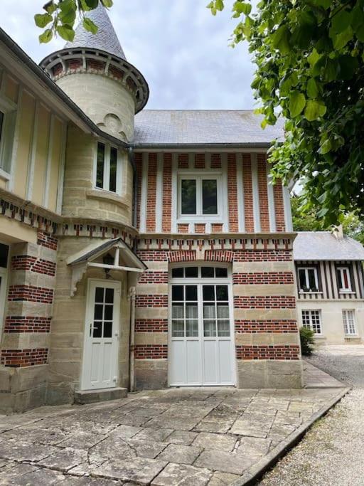 une grande maison en briques avec deux portes blanches dans l'établissement The Coach House, à Saint-Côme-de-Fresné