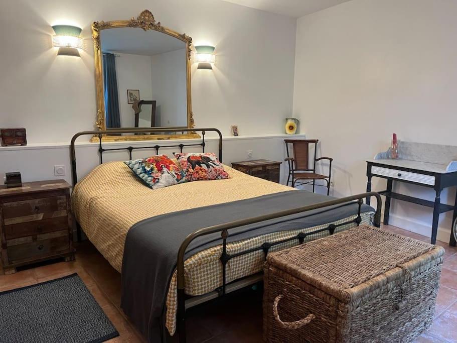 a bedroom with a bed with a mirror and a stool at The Coach House in Saint-Côme-de-Fresné