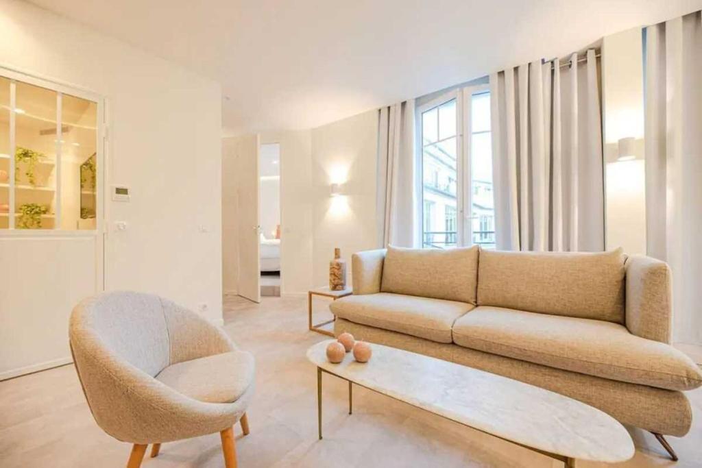 un salon avec un canapé et une chaise dans l'établissement Superb Appt with AC - 2BD-6P - Madeleine-Opera, à Paris