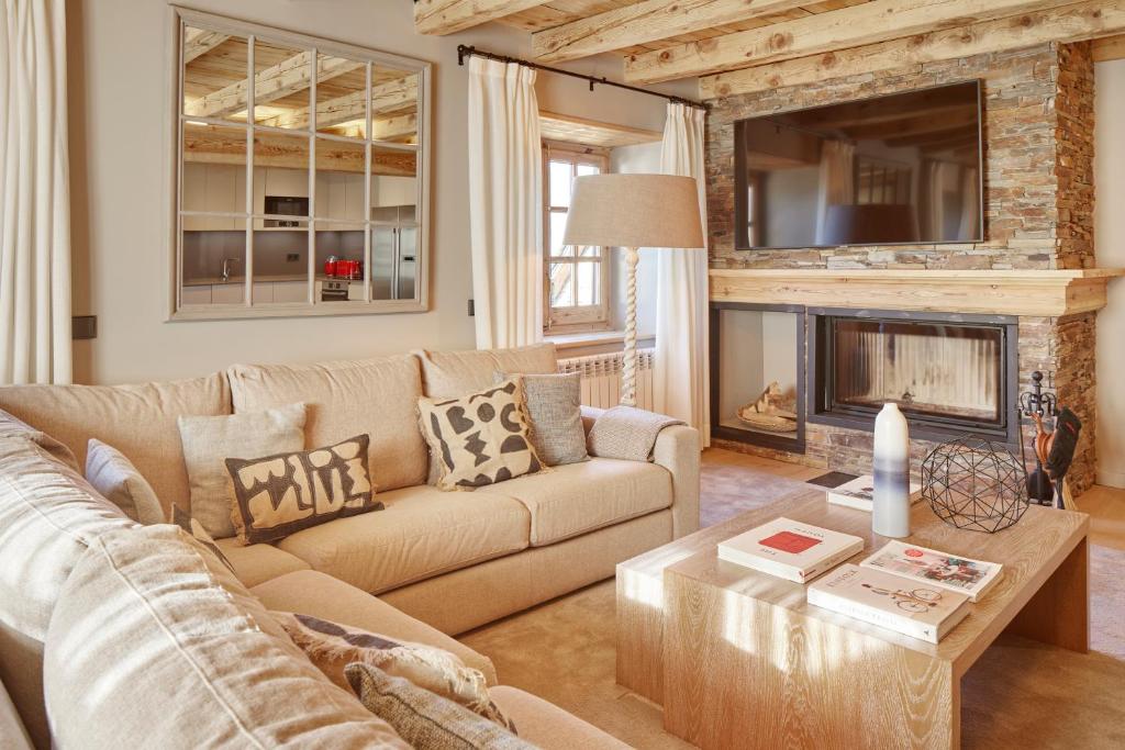 ein Wohnzimmer mit Couch und Kamin in der Unterkunft Pleta Baqueira Luxe 10 by FeelFree Rentals in Naut Aran