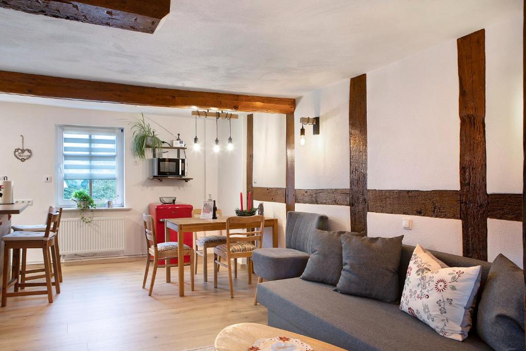 un soggiorno con un divano e un tavolo di Ferienwohnung Fachwerk 44 a Frielendorf