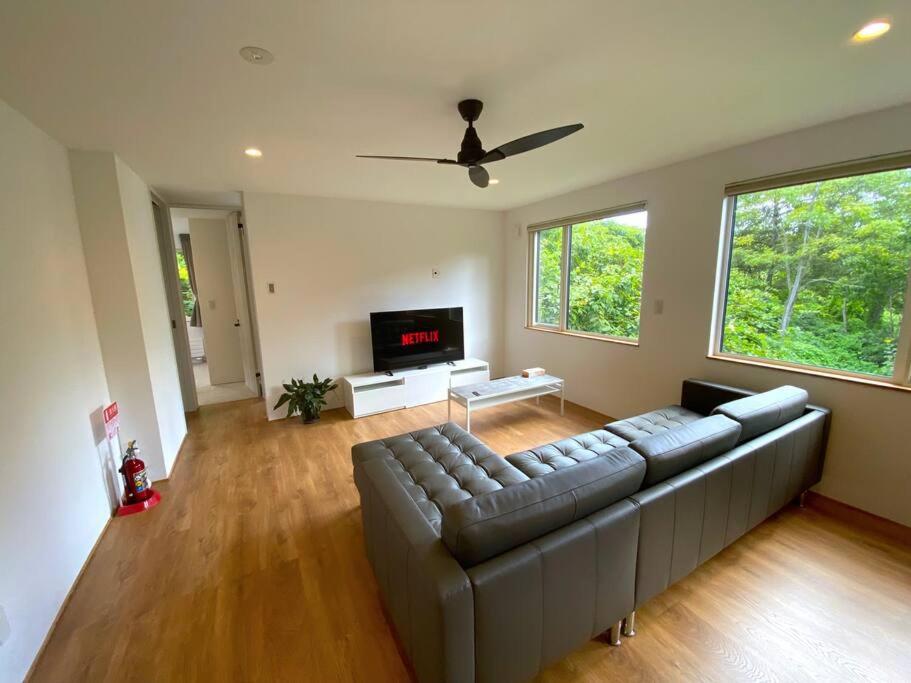 ein Wohnzimmer mit Couch und Flachbildfernseher in der Unterkunft Mopow Niseko in Niseko