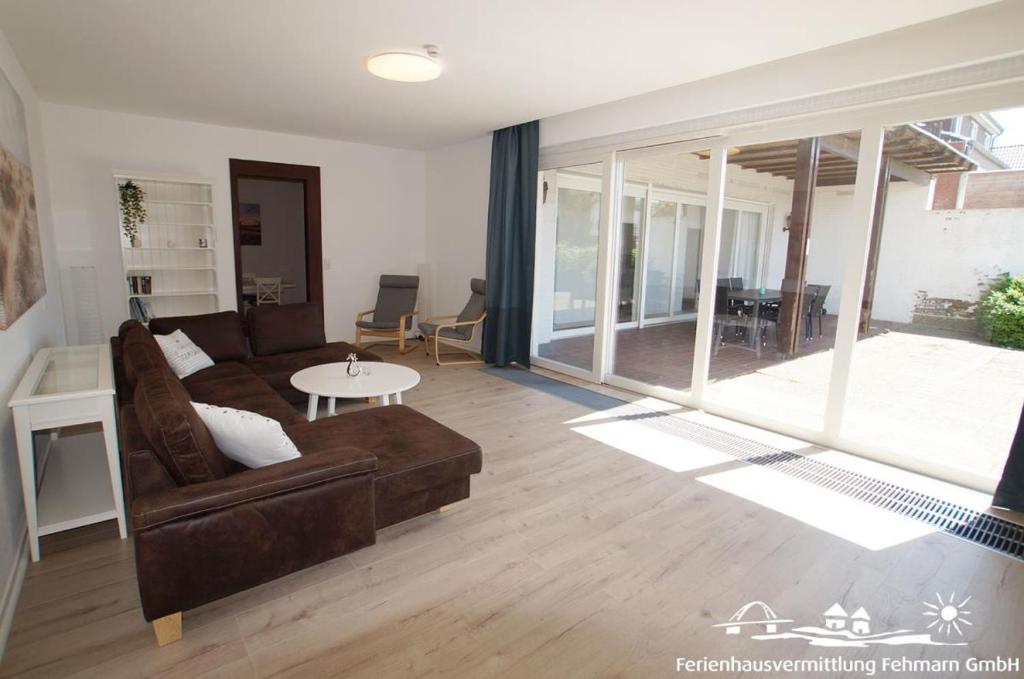 una sala de estar con un sofá y una mesa en 12 Ferienwohnung Familienzeit, en Burg auf Fehmarn