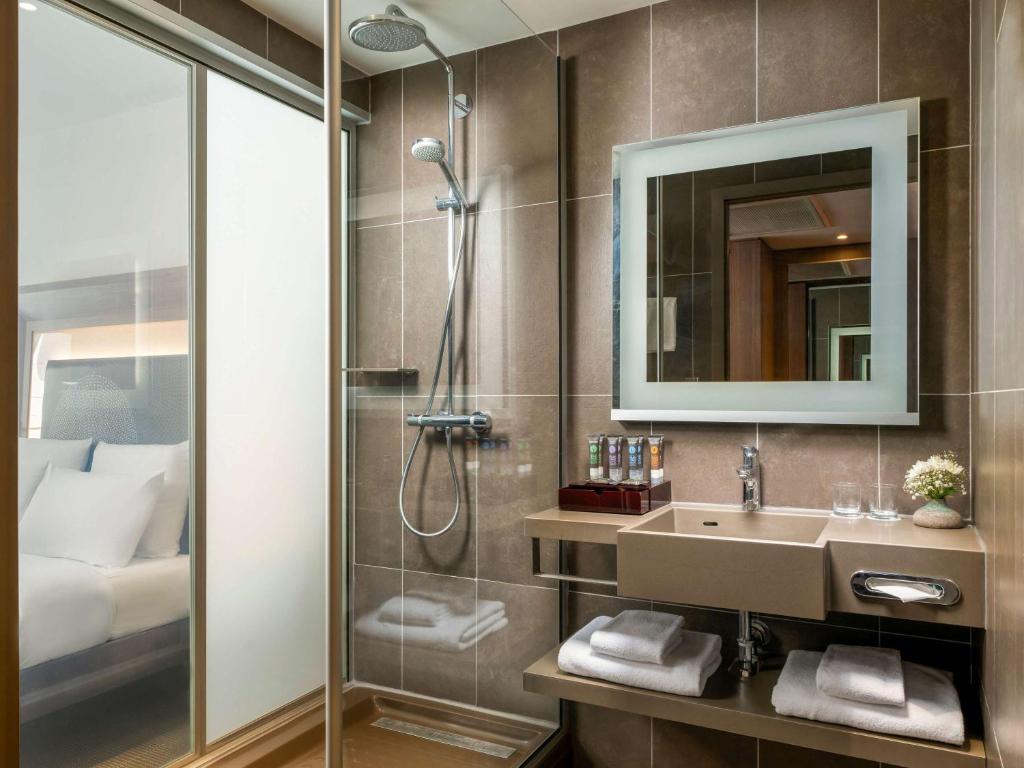a bathroom with a shower and a sink and a mirror at Novotel Istanbul Bosphorus Hotel in Istanbul