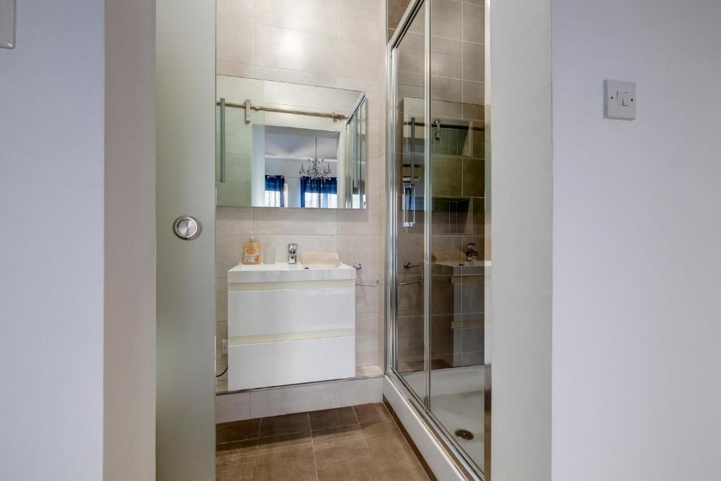 a bathroom with a sink and a shower at Modern 2BR Sliema Apartment in Sliema